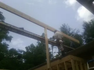 Carpenter setting a ridge beam over a new addition frame — Ice Dam Removal by Roofing Brothers in Babson Park