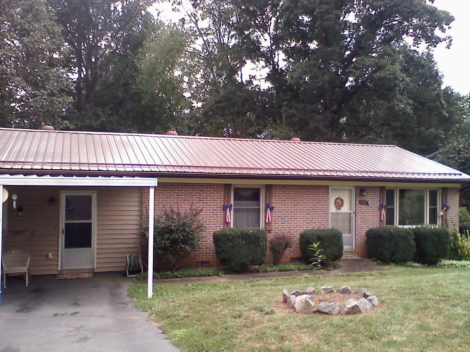 Bronze metal roof and carport on a brick ranch home — Roof Repair work by our crew in Babson Park